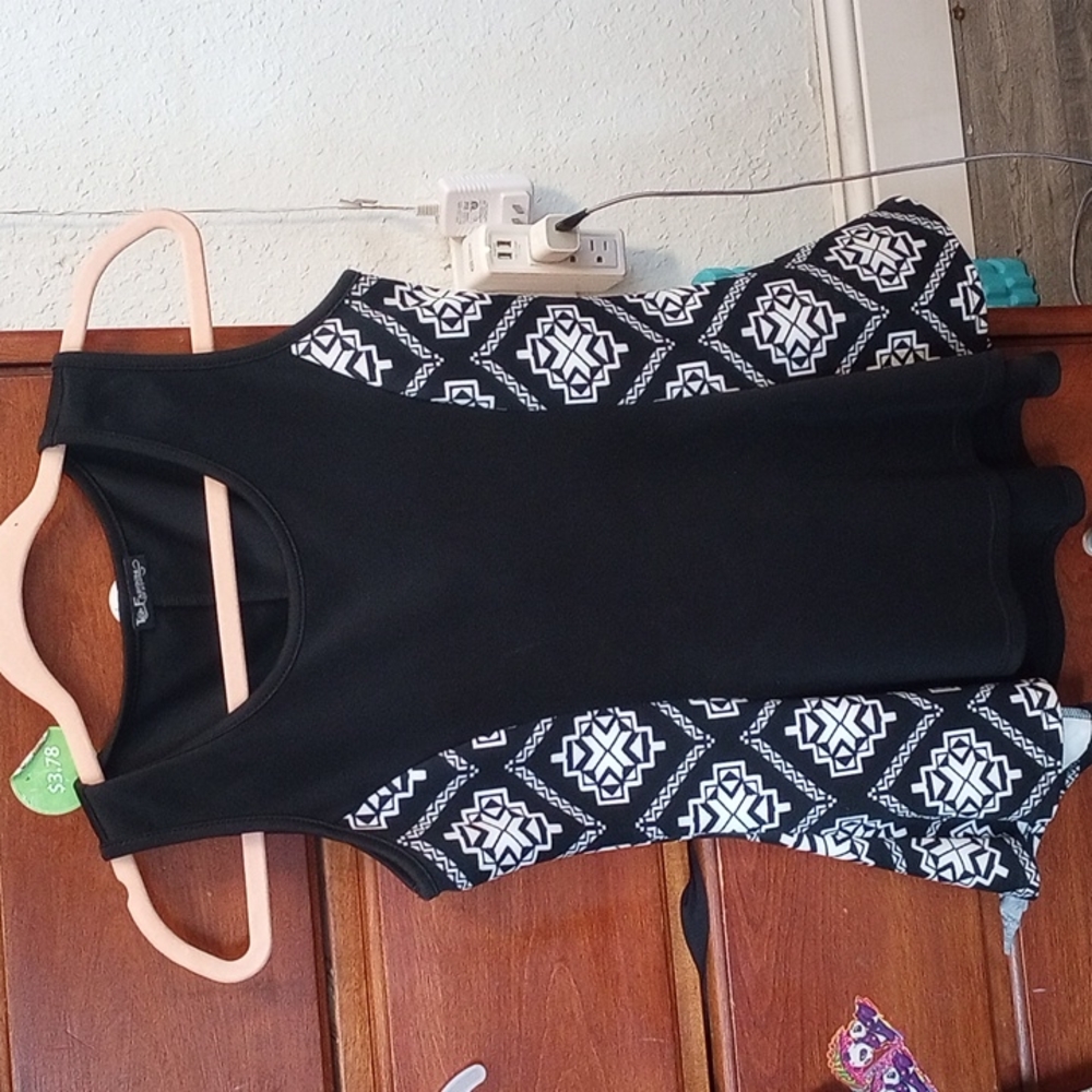 Black and White tribal design Flares out at bottom of blouse.
